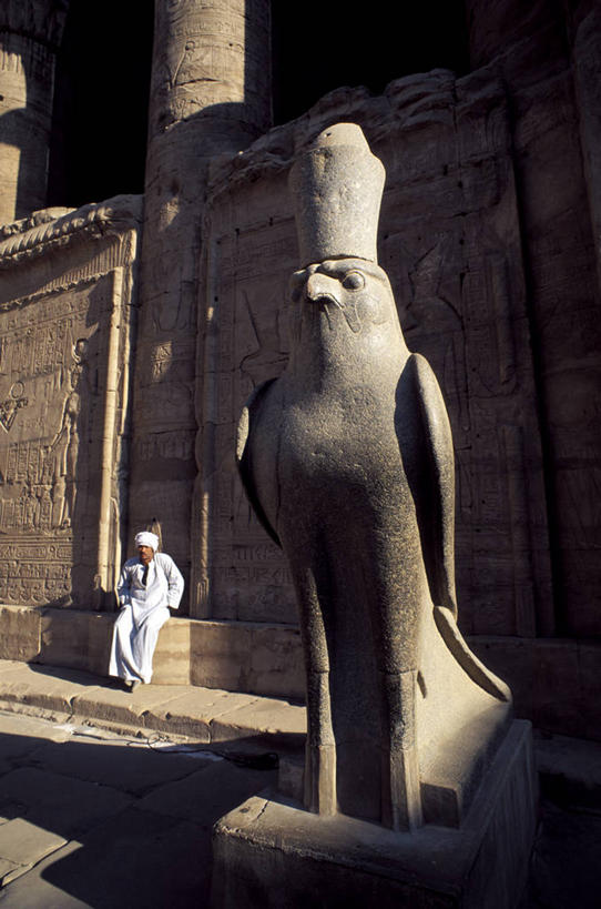 西方人,一个人,宫殿,坐,竖图,室外,白天,正面,民族服装,旅游,度假,名胜古迹,标志建筑,地标,建筑,鸟,野生动物,雕塑,欧洲,非洲,埃及,黑人,欧洲人,仅一个男性,仅一个人,行人,游客,游人,阴影,遗迹,艺术,装饰,光线,鸟类,雕刻,雕像,影子,墙,古迹,文物,娱乐,建设,古建筑,路人,旅客,墙壁,墙面,仅一个年轻男性,一个,灰色,阳光,动物,工艺品,享受,休闲,旅游胜地,放松,单个,纪念,美术,宫廷,主题,凶猛,陈列,古文明,猎鹰,阿拉伯埃及共和国,金字塔之国,棉花之国,功能,美学,阿非利加洲,王宫,隼,猎隼,过客,埃德富,埃德富神庙,荷鲁斯神殿,残暴,凶残,男人,男性,年轻男性,非洲人,鸮,坐着,彩图,全身,传统服装,民俗服,皇宫