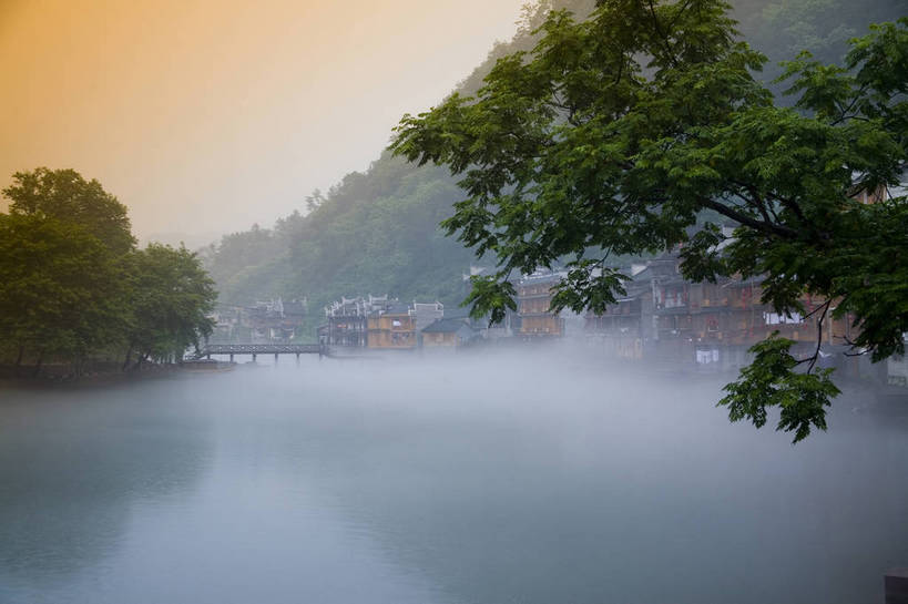 横图,彩色,室外,白天,旅游,度假,名胜古迹,山,雾,标志建筑,地标,建筑,船,中国,亚洲,遗迹,民俗,图片,文化遗产,建筑群,古典,古迹,文物,娱乐,建设,古建筑,民居,游船,树木,古镇,享受,休闲,旅游胜地,薄雾,放松,摄影,美好,文明,中国文化,古文明,东亚,湖南,凤凰镇,中华人民共和国,幽静,江,旅行,传统文化,bj174